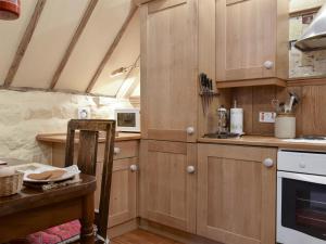 a kitchen with wooden cabinets and a table at The Hayloft - Igp in Glaisdale
