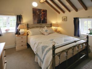 ein Schlafzimmer mit einem Bett und zwei Fenstern in der Unterkunft Chestnut Cottage - E5625 in Wainfleet All Saints