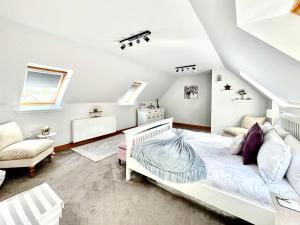 ein weißes Schlafzimmer mit einem Bett und einem Stuhl in der Unterkunft Rose Cottage in Dingwall