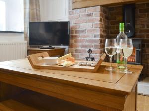 a table with two glasses of wine and cheese at Eithinog Ganol in Llandwrog