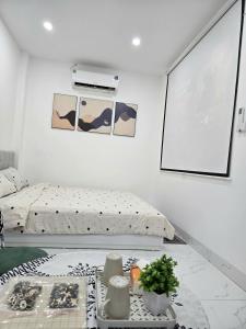 een slaapkamer met een bed en een tafel met vazen bij Hea Apartment in Hanoi