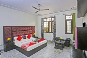 a bedroom with a large bed with red pillows at Hotel O Delhi Heights 2.0 Home stay in New Delhi