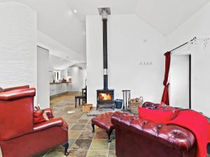a living room with leather furniture and a fireplace at Kite Cottage in Capel-Ifan +25 photos