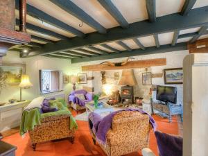 a living room with purple chairs and a tv at Hen Dy-Qc56 in Dolbenmaen