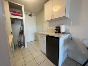 une cuisine avec des armoires blanches et un lave-vaisselle noir dans l'établissement A Homie Getaway! Double Bed Studio with a VIEW, à Honolulu