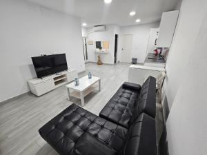 a living room with a leather couch and a table at Apartamento mi currilla in Sanlúcar de Barrameda