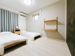 Un dormitorio con dos camas y una ventana en 临近京瓷大阪巨蛋大正地铁站jr环状线站全新別墅, en Wada