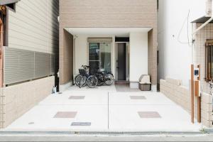 Un grupo de bicicletas estacionadas afuera de un edificio. en 临近京瓷大阪巨蛋大正地铁站jr环状线站全新別墅, en Wada