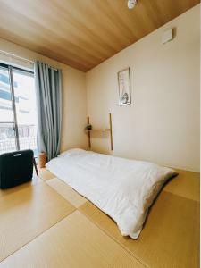 Un dormitorio con una cama blanca y una ventana. en 临近京瓷大阪巨蛋大正地铁站jr环状线站全新別墅, en Wada