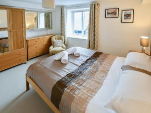 a bedroom with a large bed and a chair at 5 Balmoral House in Keswick