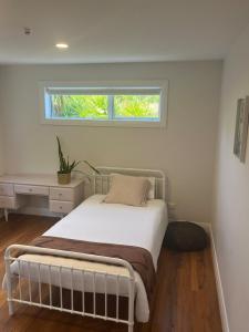 ein Schlafzimmer mit Bett, Schreibtisch und Fenster in der Unterkunft Cable Bay Seaview Beauty in Cable Bay