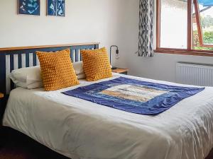Un dormitorio con una cama grande con almohadas amarillas. en Beech House, en Torcastle 17 fotos más