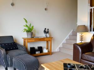 a living room with a chair and a table at Morlais - Hw7599 in Llanaber