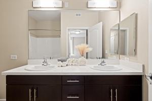 ein Badezimmer mit zwei Waschbecken und einem großen Spiegel in der Unterkunft Great 2bd 2bath in MdR! Free parking and pool! in Los Angeles