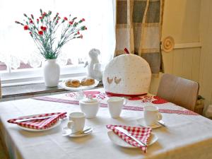 a table with a table cloth with a cake on it at Tanner's Cottage in Cockermouth