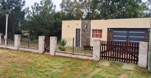 a fence in front of a house with a garage at Es aca in Jaureguiberry