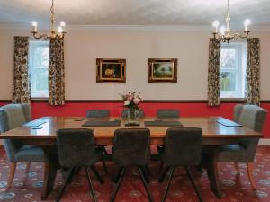 a dining room with a wooden table and chairs at Brompton Lodge in Ganton