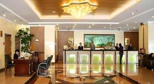 昆明市にあるKunming Greenlake View Hotelのバーの周りに人々が立っているホテルのロビー