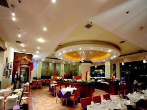 Un restaurante con mesas y sillas y un bar. en Dongguan Castfast Hotel, en Qinglinjing