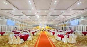 un gran salón de banquetes con mesas y sillas rojas y blancas en Dongguan Castfast Hotel, en Qinglinjing 250 fotos más