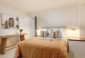 a bedroom with a large bed with pillows at Pure Indulgence in Merimbula