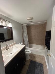 a bathroom with a sink and a toilet and a tub at Private separate entrance suite in Oshawa