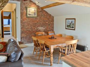 een eetkamer met een houten tafel en stoelen bij The Old Stables in Helsby