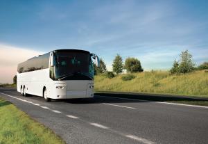 a white bus is driving down a road at City Express By Marriott Gettysburg in Gettysburg