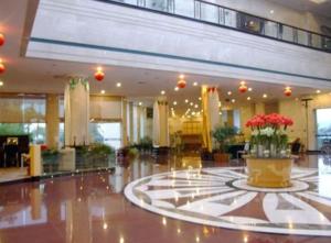a lobby with a large lobby with flowers in a pot at Tiantai Hotel in Tiantai +215 photos