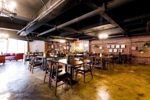 ein Restaurant mit Tischen und Stühlen und einer Backsteinmauer in der Unterkunft James Joyce Coffetel Xi'an Laochenggen Hongmiaopo Metro Station in Xi'an