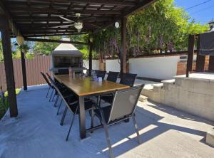 een houten tafel en stoelen onder een pergola bij Luxury Pool Villa Aurora in Hrebinec