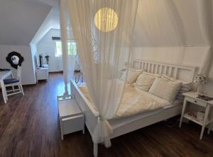 een slaapkamer met een wit bed met een hemelbed bij Luxury Pool Villa Aurora in Hrebinec +55 foto's