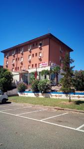 a large building with a parking lot in front of it at Hotel Parigi in Castel San Pietro Terme