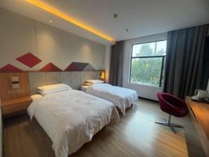 a hotel room with two beds and a window at Borrman Hotel Jingzhou Jiangjin West Road Wanda Plaza Fantawild in Caoshi