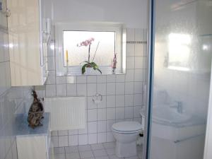 ein weißes Bad mit einem WC und einem Fenster in der Unterkunft Ostseehaus Oe in Sierksdorf