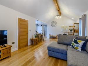 a living room with a couch and a television at Rinstone Lodge in Thornton Dale