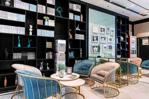 een kamer met stoelen, tafels en boekenplanken bij Xana Hotelle Luzhou High-Speed Railway Station Trading Market Passenger Terminal in Luzhou