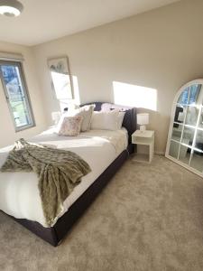 a bedroom with a large bed and a window at 138 On The Bay - Sunset Bliss on the Waters Edge in Murdunna
