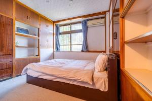 une petite chambre avec un lit et une fenêtre dans l'établissement Kumi No Yado Gettou - Vacation STAY 31704v, à Kadekaru
