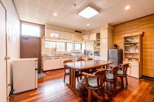 une cuisine avec une table, des chaises et un réfrigérateur dans l'établissement Kumi No Yado Gettou - Vacation STAY 31704v, à Kadekaru