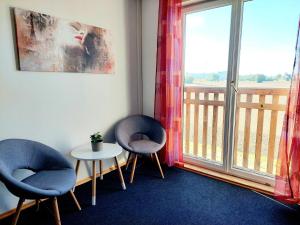 two chairs and a table in a room with a window at Guesthouse Graz Central for 9 People in Graz