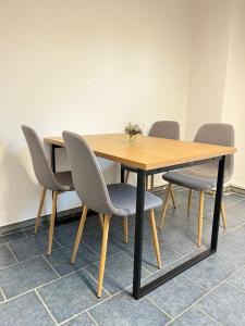 Una mesa de madera con cuatro sillas alrededor. en M&K Homes Unterkunft bei Lübeck, en Selmsdorf