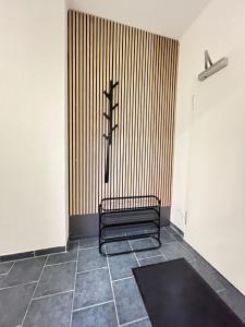 Un banco negro en una habitación con una cruz en la pared. en M&K Homes Unterkunft bei Lübeck, en Selmsdorf