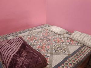 a room with a table with a quilt on it at Rajput restaurant and hotel in Ahraurā Road