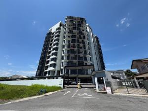 a tall building with a parking lot in front of it at Spacious 3BR Homestay - Trinity Residence Kuching City in Kuching