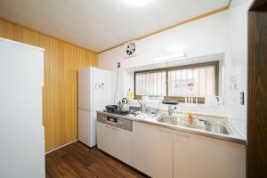 a kitchen with a sink and a white refrigerator at Yufu no Yu Raku - Vacation STAY 18768v in Yufuin