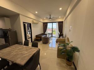 a dining room and living room with a table and chairs at Spacious 3BR Homestay - Trinity Residence Kuching City in Kuching