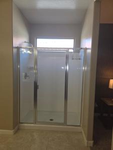 a glass shower in a bathroom with a window at Comfortable Family Getaway in Buckeye in Buckeye