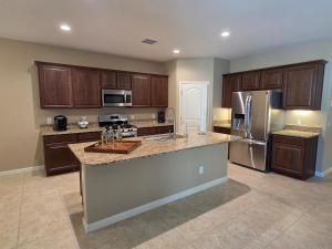 a large kitchen with wooden cabinets and stainless steel appliances at Comfortable Family Getaway in Buckeye in Buckeye +9 photos