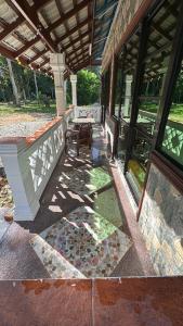 a porch of a house with a table and windows at D'Kebun Lenggong Perak Chalet in Gua Sai +1 photo